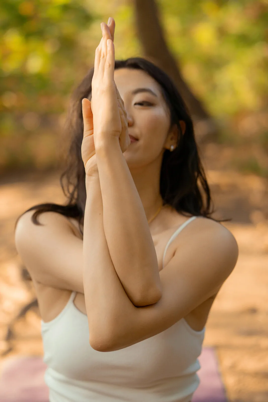 Ashley with her hands in prayer, outdoors