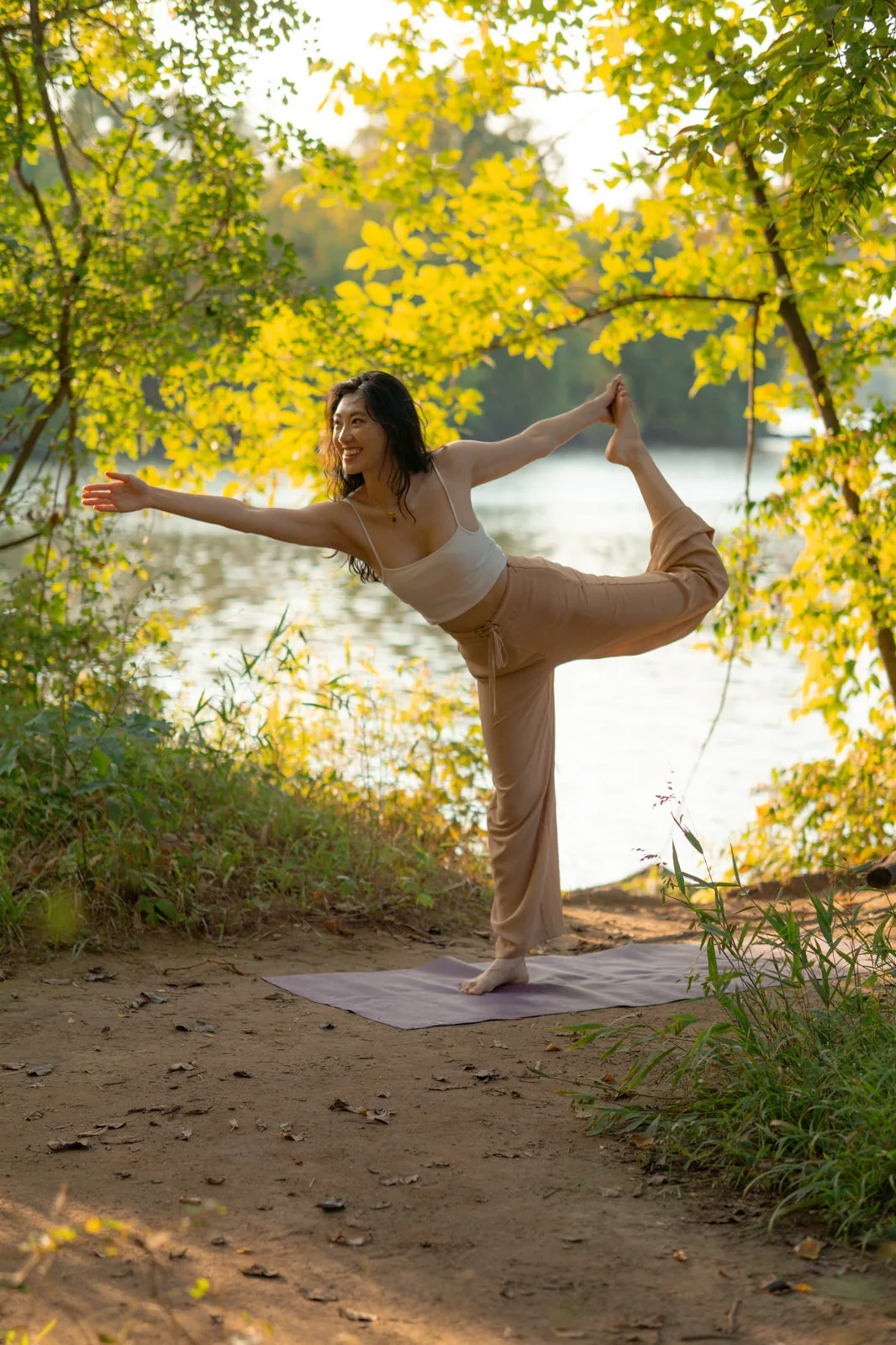 Ashley in dancer's pose on a lakeside trail